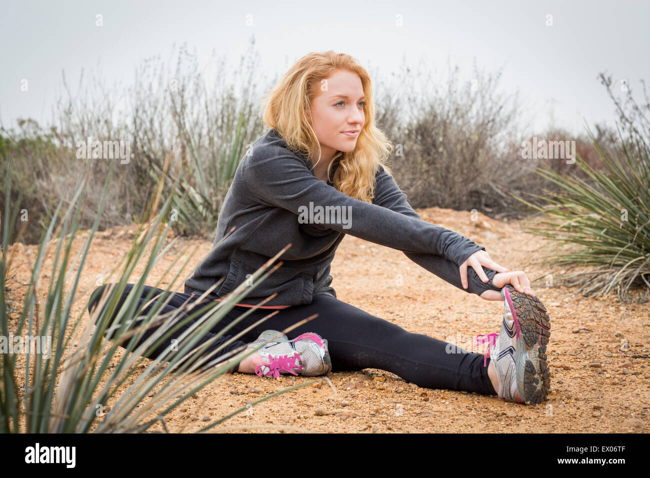Junge weibliche Läufer, stretching, um die Zehen zu berühren Stockfoto
