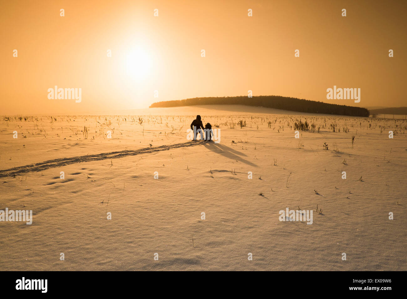 Silhouette Mann und Sohn wandern im Schnee bedeckte Landschaft bei Sonnenuntergang, Sarsy Dorf, Swerdlowsk, Russland Stockfoto