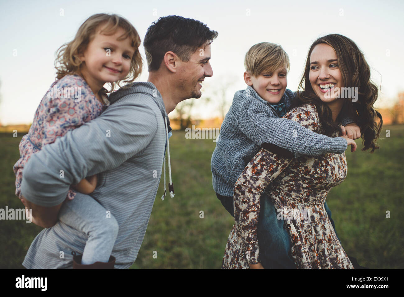 Junges Paar mit Sohn und Tochter Piggy Rücken im Feld Stockfoto