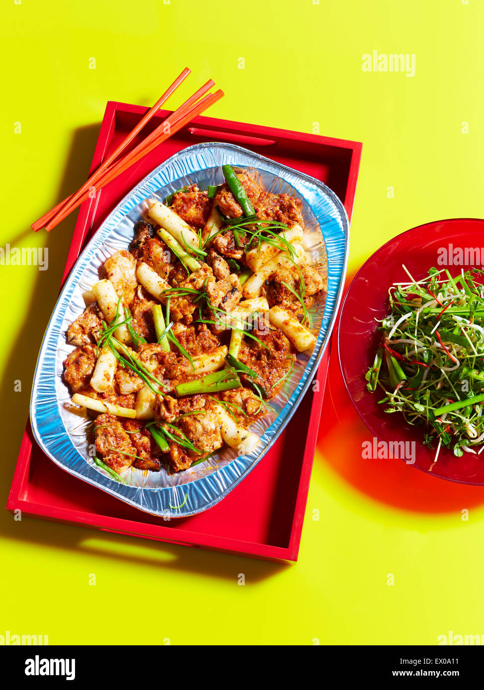Stillleben mit Tablett mit rühren gebraten Huhn und Salat Stockfoto