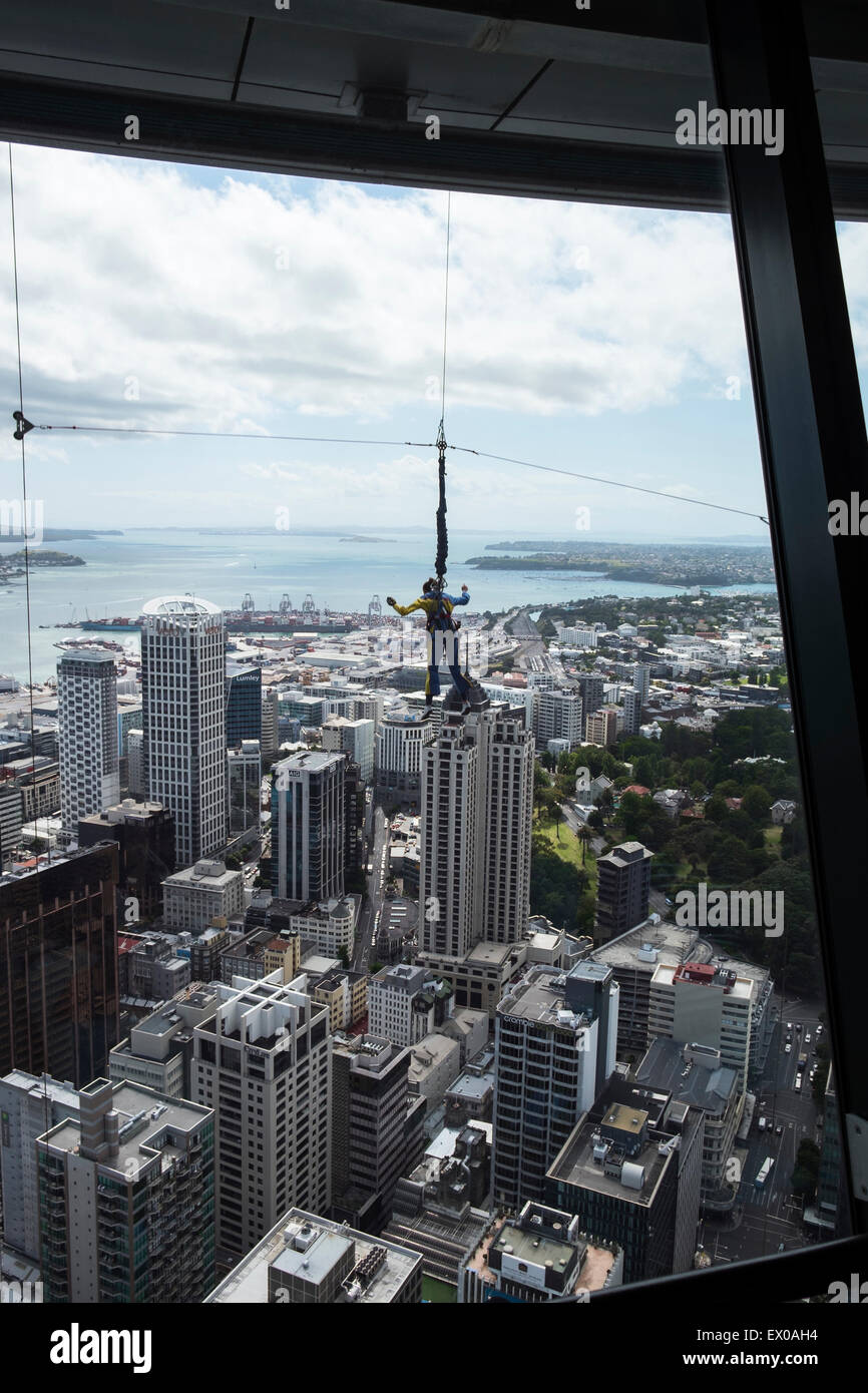 Blick auf Auckland City vom Boden in den Skytower Beobachtung als eine Frau Skyjumps von oben, Neuseeland Stockfoto