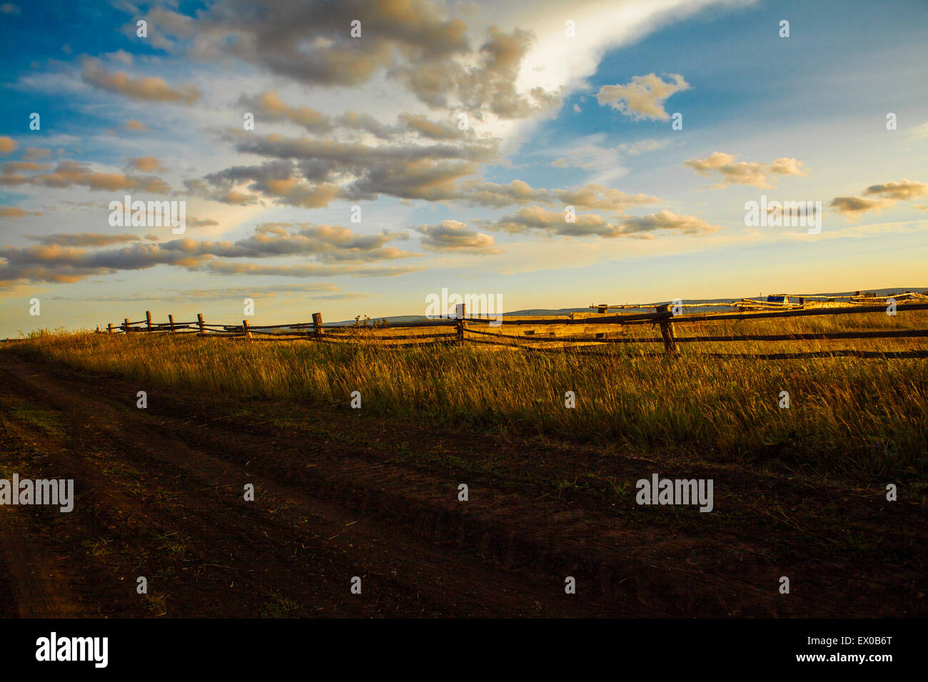 Dirt Track &amp; Field bei Sonnenuntergang, Sarsy Dorf, Sverdlovsk Oblast, Russland Stockfoto