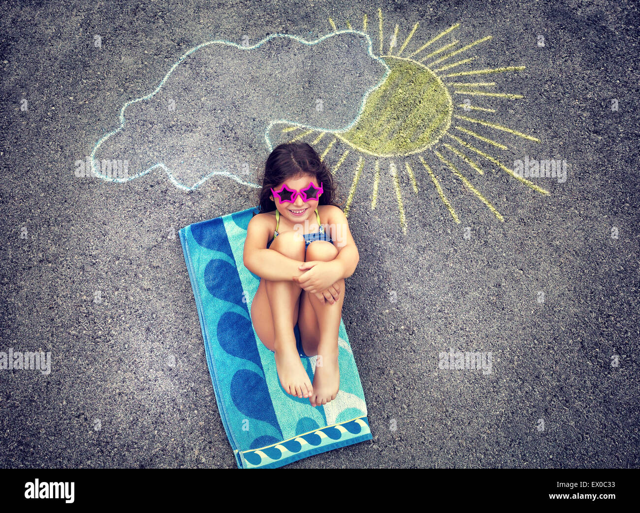 Kreatives kleines Mädchen zeichnen auf Asphalt Sonne und Solarium, tragen stilvolle Badeanzug und Sonnenbrille, Sommerferien Stockfoto
