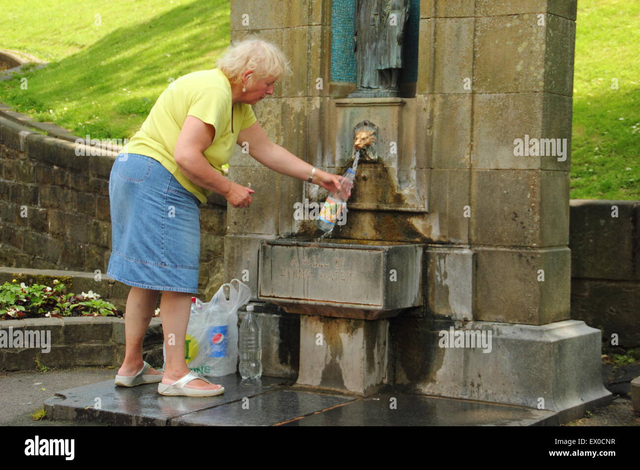 Eine Frau füllt Flaschen mit Trinkwasser aus Saint Ann gut in Buxton, Derbyshire während einer Hitzewelle - England UK, Juli 2015 Stockfoto