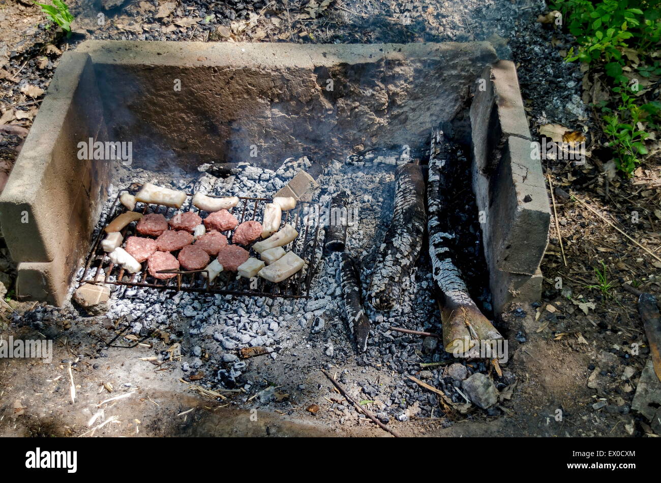 Über glühende Kohlen vom offenen Feuer kochen Steaks Stockfoto
