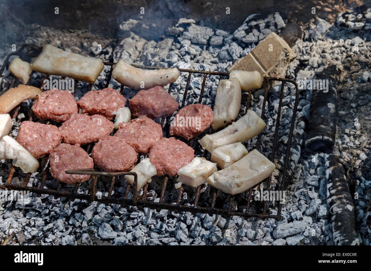 Über glühende Kohlen vom offenen Feuer kochen Steaks Stockfoto