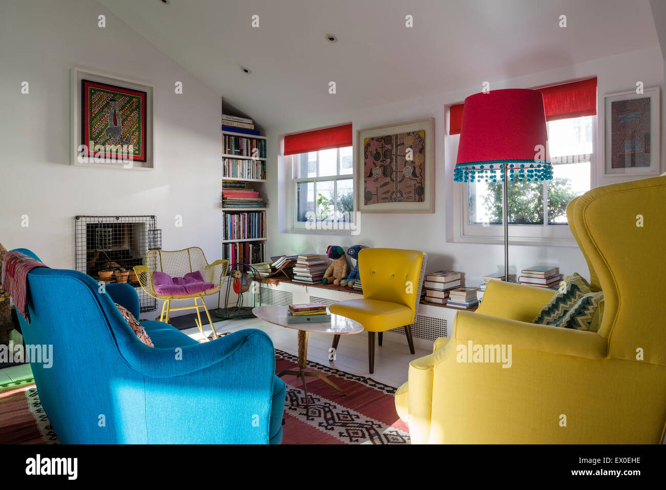 Kühnen blauen Sofa, Julep Stuhl und Eames Wire Schaukelstuhl im Wohnzimmer mit Aborigines Wandkunst Stockfoto