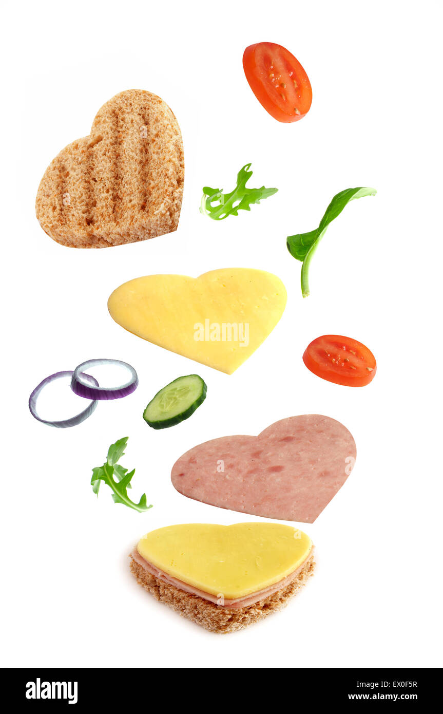 Herz-Form-Sandwich-Zutaten fallen an ihren Platz Stockfoto