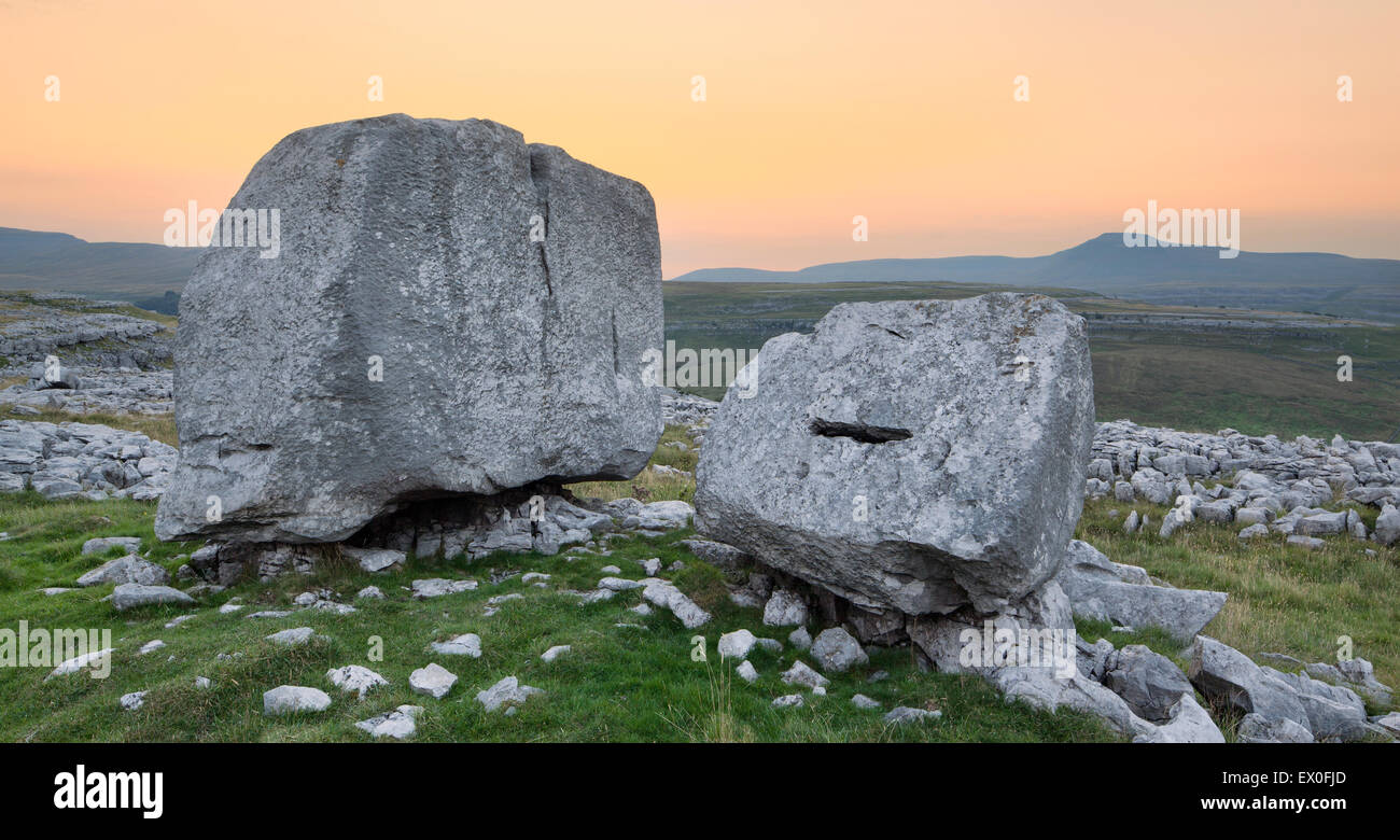 Findlinge am Keld Kopf Narbe im Hinblick auf die Ingleborough Hügel am Sonnenaufgang, Kingsdale, Yorkshire Dales, North Yorkshire, UK Stockfoto