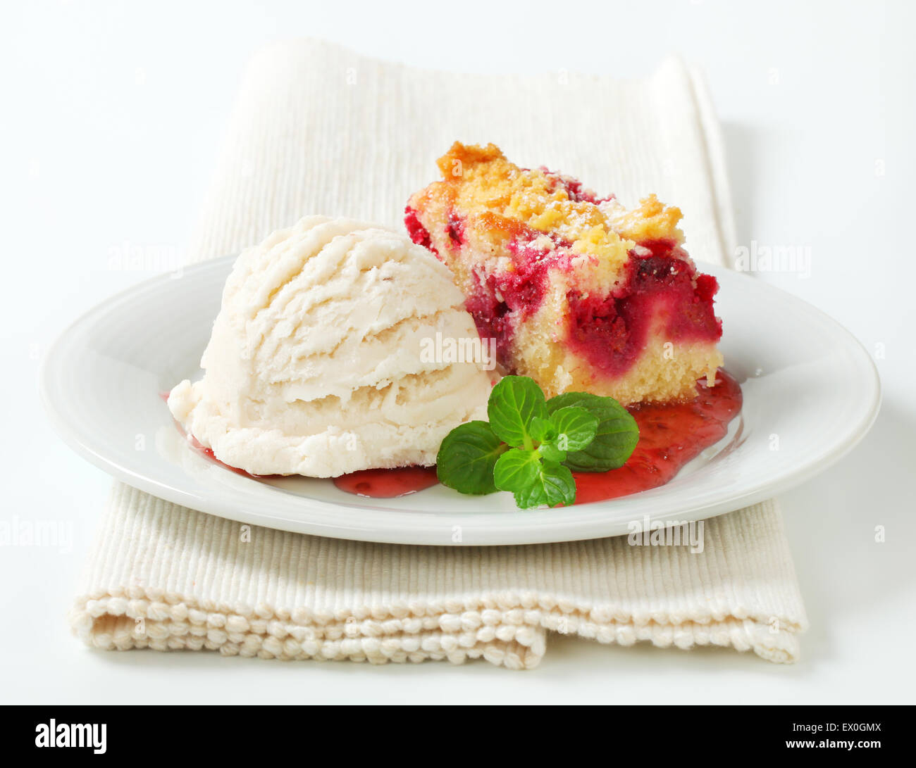 Beerenfrucht bröckeln Slice mit Eis und Himbeersauce Stockfoto