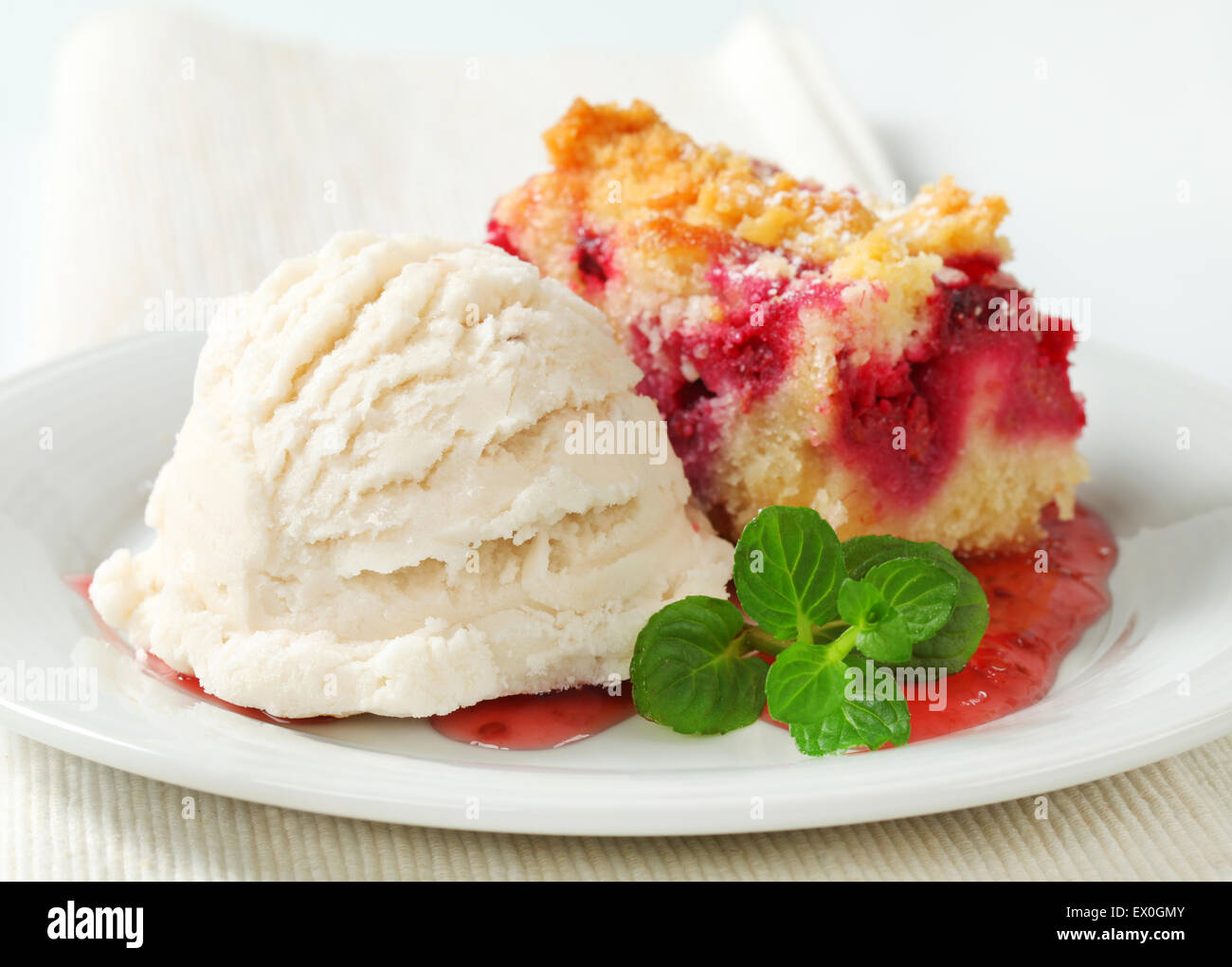 Beerenfrucht bröckeln Slice mit Eis und Himbeersauce Stockfoto