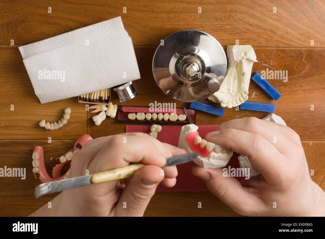 der Zahntechniker beschäftigt sich mit einer Modellierung von Zahnersatz Stockfoto