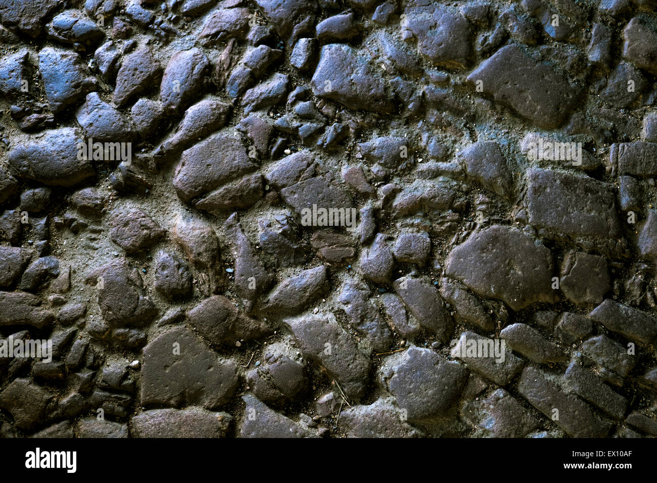 Blick auf einen alten gepflasterten Weg mit Lichteinfall von der Seite. Stockfoto