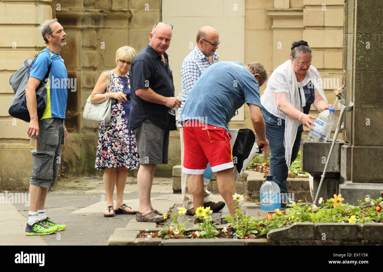 Menschen versammeln, um Flaschen mit Wasser aus Saint Ann in Buxton gut zu füllen, während sehr heißes Sommerwetter Derbyshire England UK Stockfoto