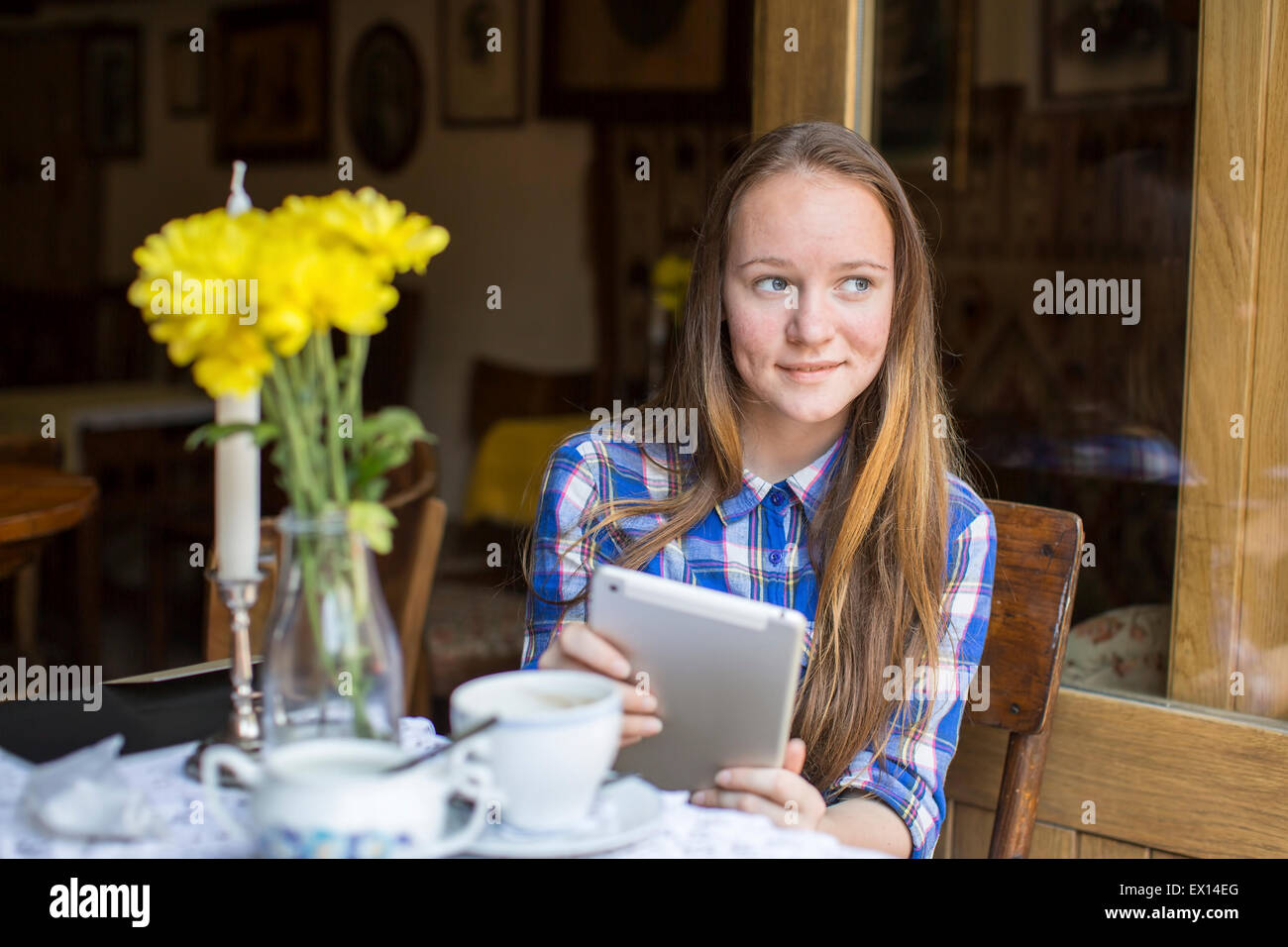 Teenager-Mädchen mit einem Tablet in der Cafeteria sitzen. Stockfoto