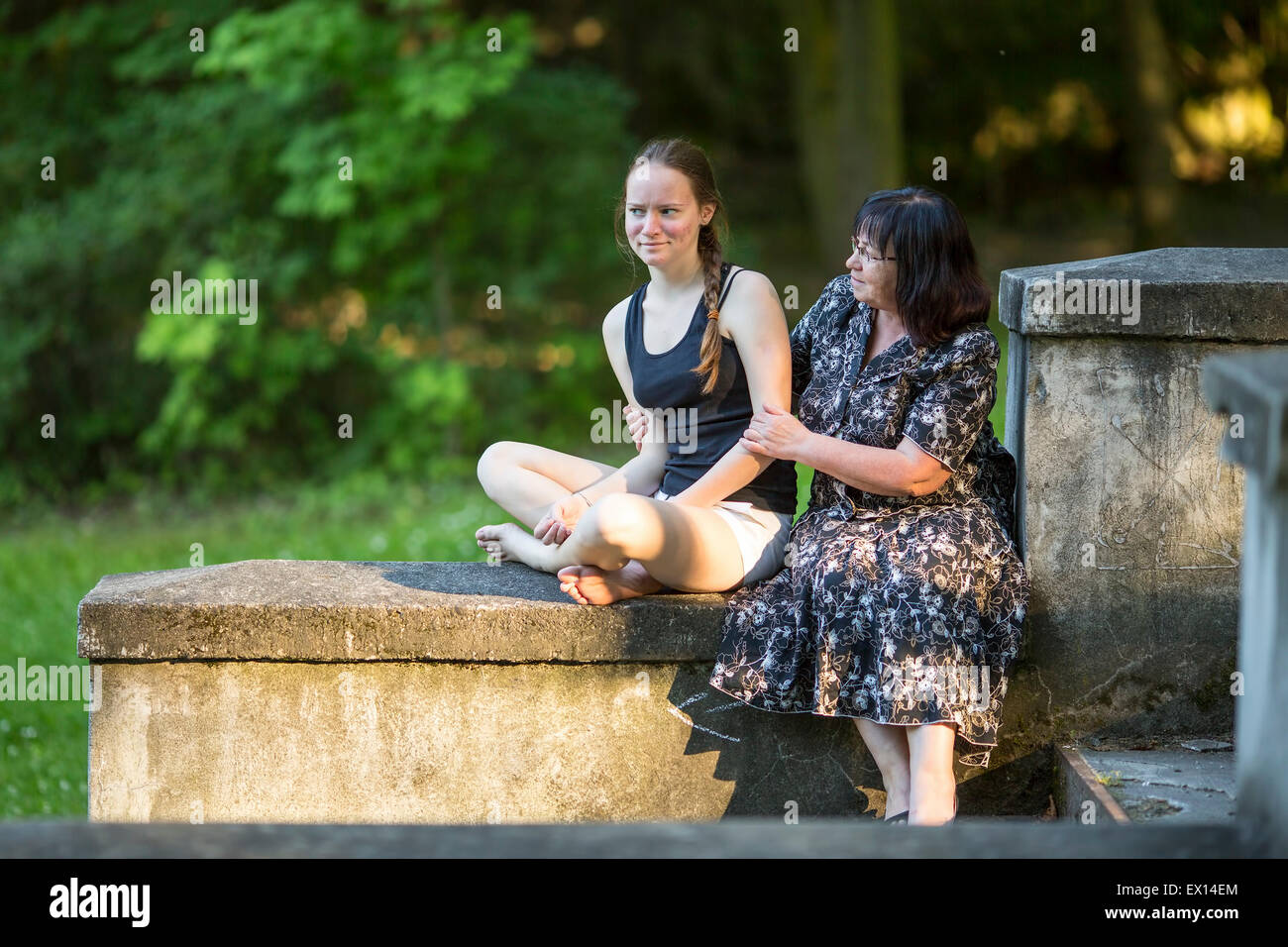 Teenager-Mädchen im Gespräch im Park mit seiner Großmutter. Stockfoto