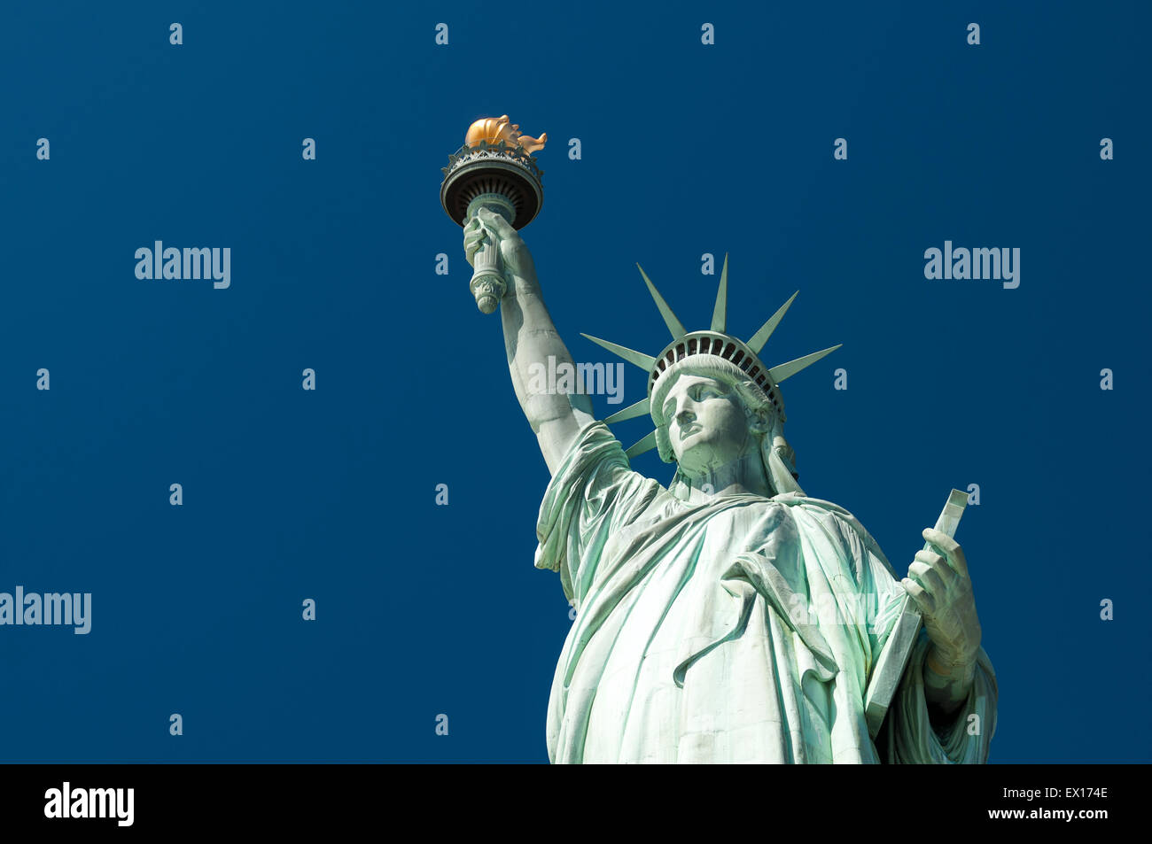 Blick nach vorne auf die Freiheitsstatue mit ihrer Fackel gegen klar strahlend blauer Himmel Stockfoto