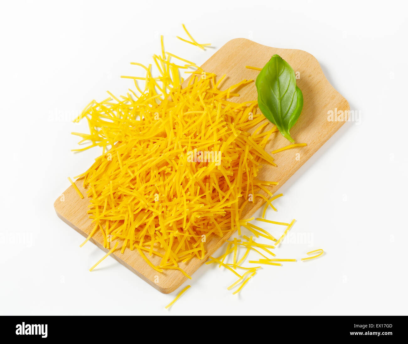 Haufen von Suppennudeln auf Schneidebrett Stockfoto