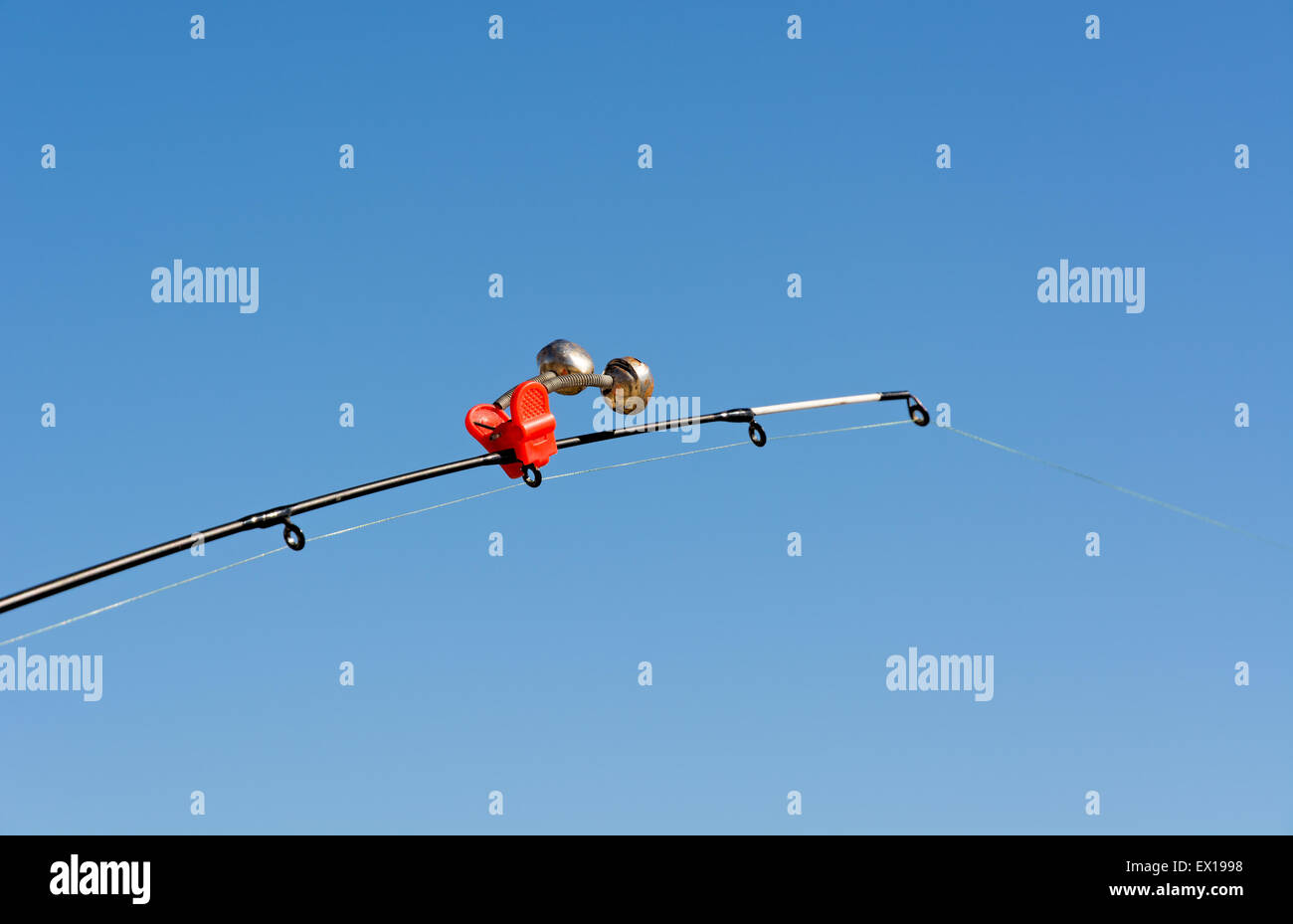 Spitze der Angelrute mit rote Glocke gestreckt Angelschnur gegen den  strahlend blauen Himmel. Close-up. Flachen DOF Stockfotografie - Alamy