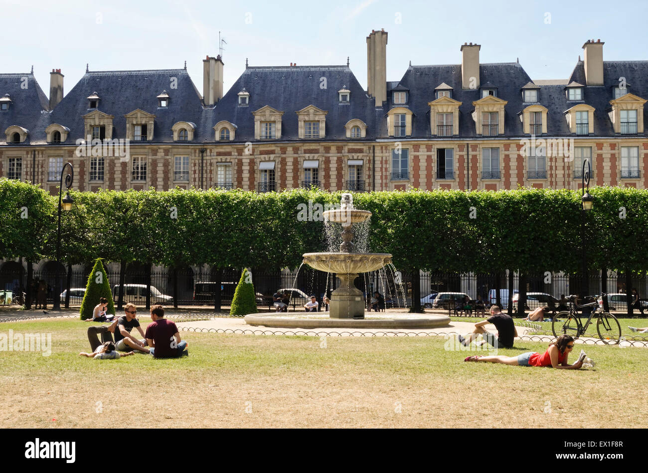 Touristen im Sommer Hitzewelle in der Nähe von Brunnen am ältesten Platz, Place des Vosges, Paris, Frankreich. Stockfoto