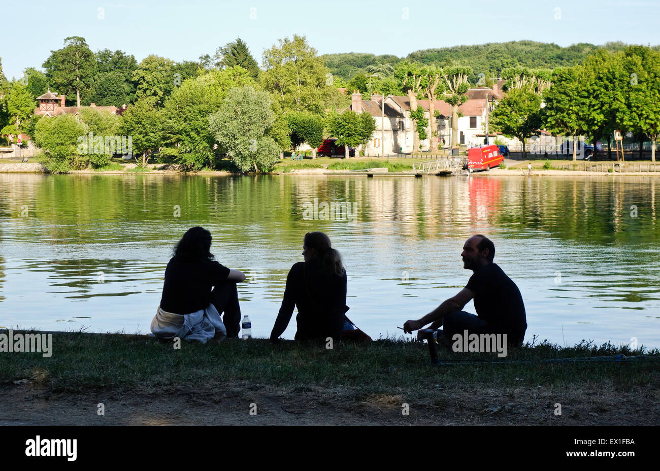 Drei Personen genießen und entspannen, sitzen am Seineufer, Samois-Sur-Seine, Frankreich. Stockfoto