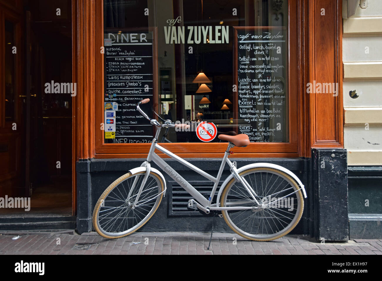 Ein Fahrrad parkte neben einem keine Fahrräder Zeichen vor Cafe Van Zuylen auf Torensteeg Straße in Amsterdam, Holland Stockfoto
