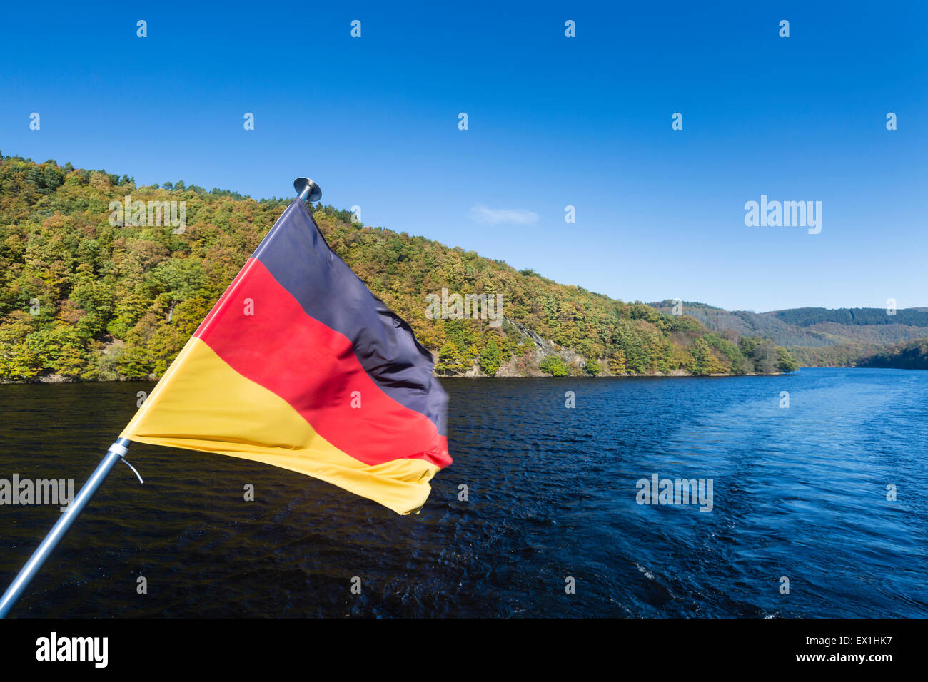 Deutsche Flagge auf einem Schiff auf See Rursee mit blauen Himmel und Sonne im Sommer. Stockfoto