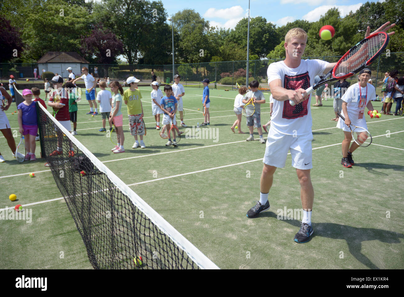 Kyle Edmund (britische Nummer 4) gab seiner Zeit um Trainer Kinder in Wimbledon Park am mittleren Wochenende der Meisterschaften Stockfoto