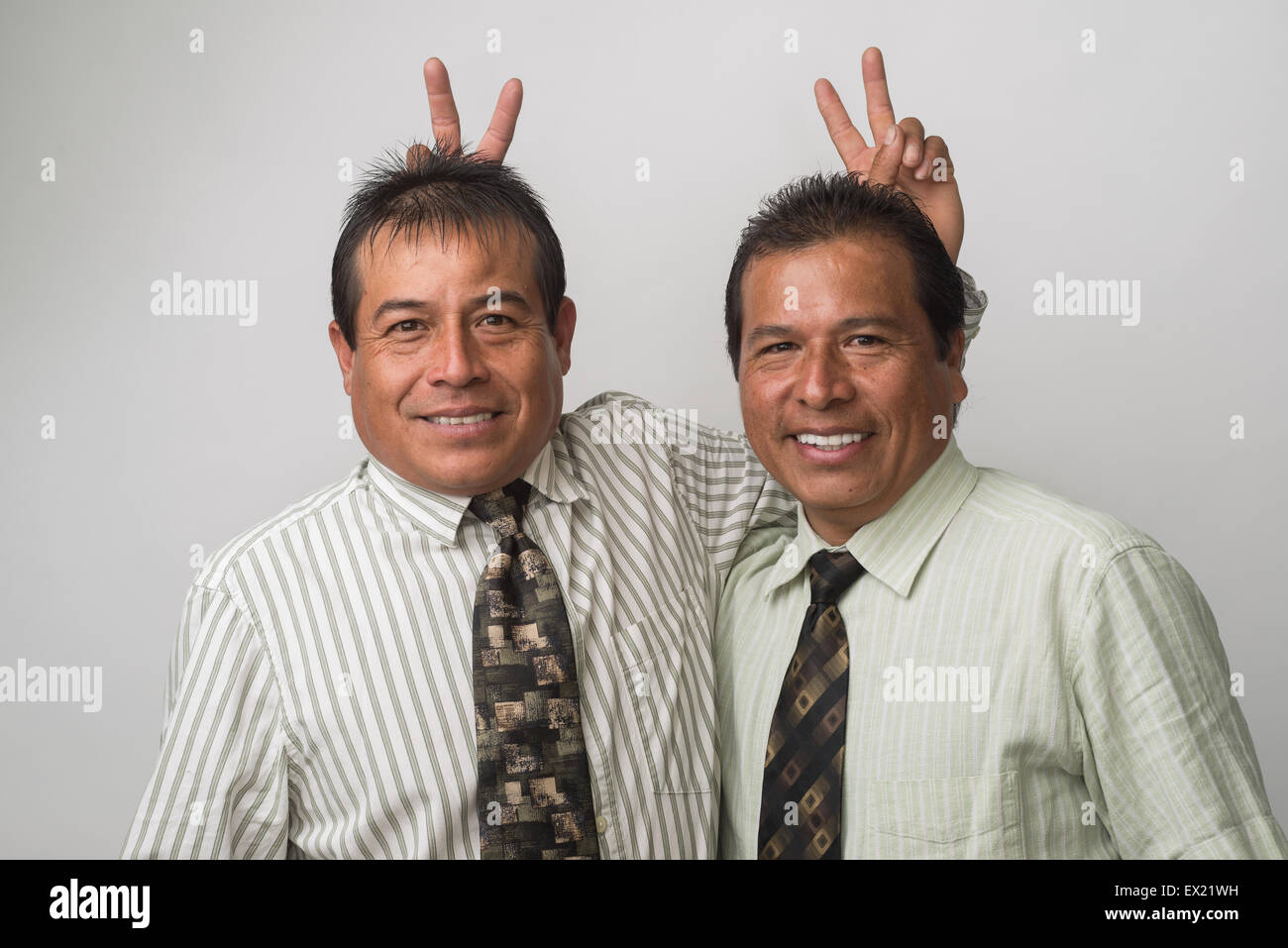 Hispanische Geschäftsleute, Büroangestellte, Lächeln, Spaß, Hasenohren auf einander! Stockfoto