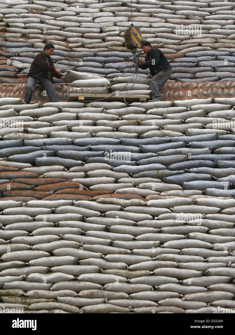 Zwei Arbeiter tragen einen Sandsack zur Behebung Steigungschutz neben 318 Nationalstraße in Suining, Provinz Sichuan, 10 Januar 201 Stockfoto