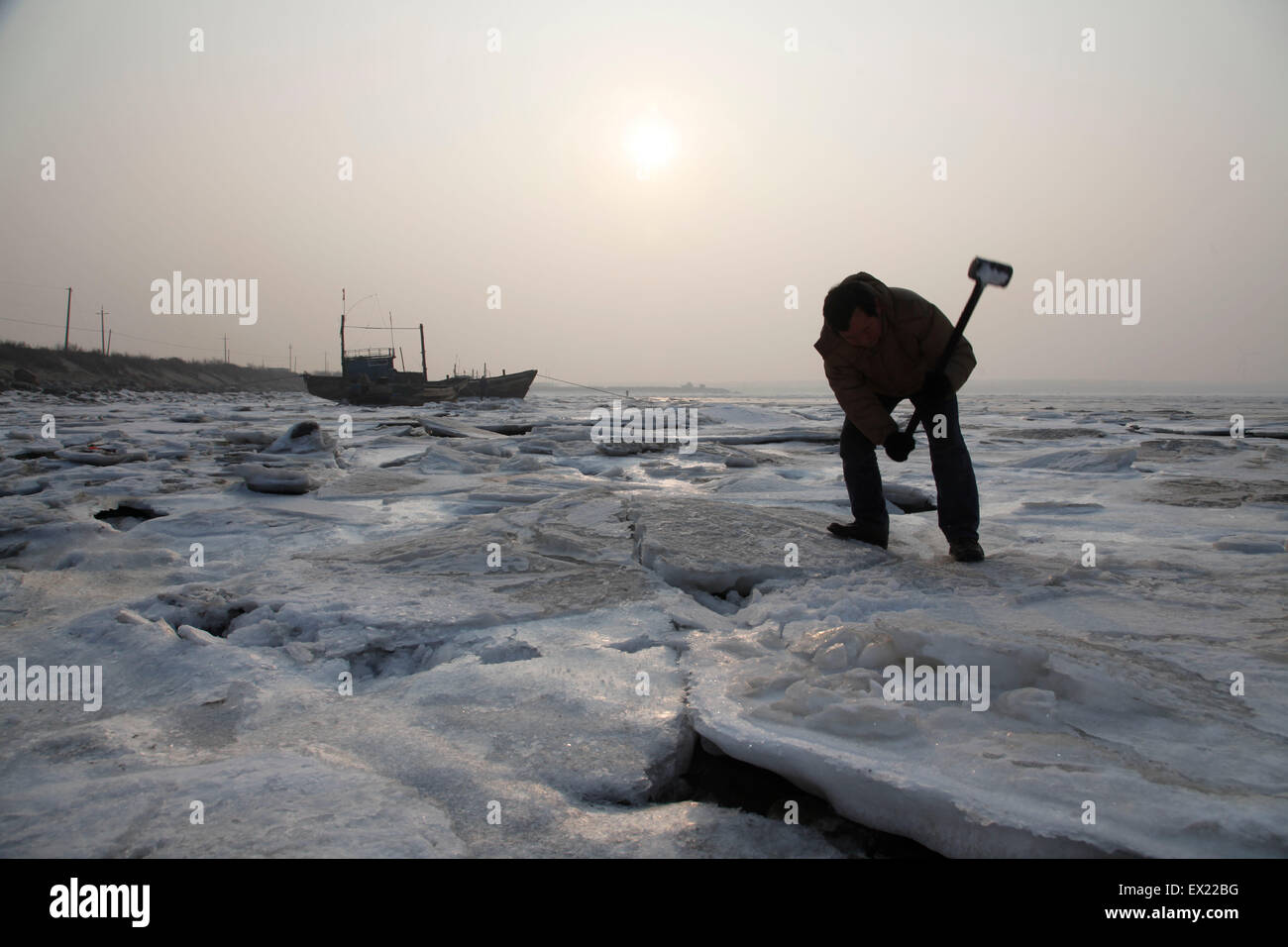 Ein Fischer bricht das Eis ein Seil festmachen eines Bootes (nicht im Bild) lösen also, halten Sie es an einem sicheren Abstand von anderen o Stockfoto