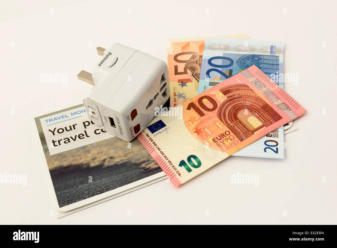 International Travel Plug und Euro-banknoten isoliert auf weißem Hintergrund Stockfoto