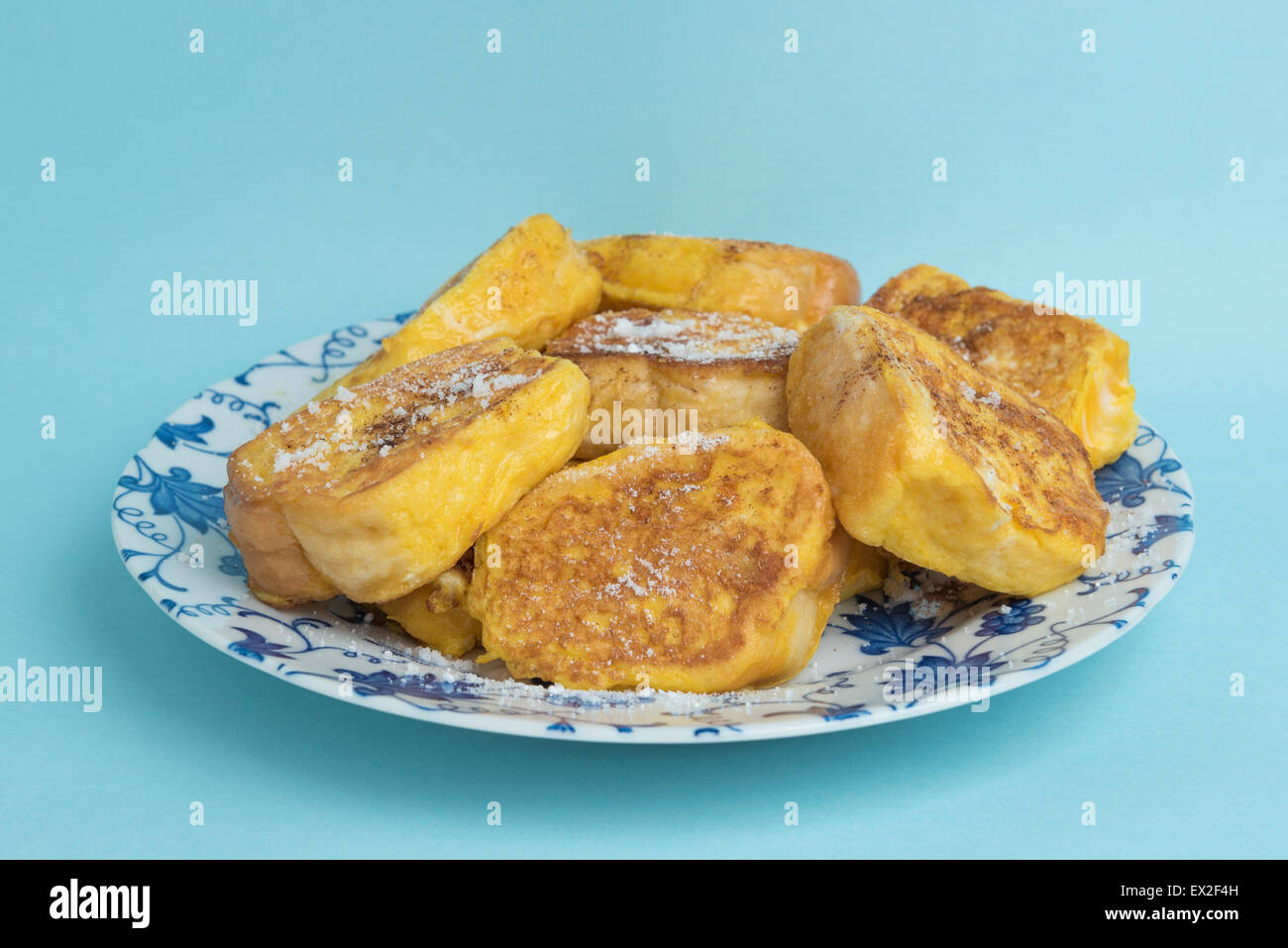 Ein Teller mit French Toast auf einen weiß und blau floral gestaltet-Platte auf einem hellblauen Hintergrund. Stockfoto