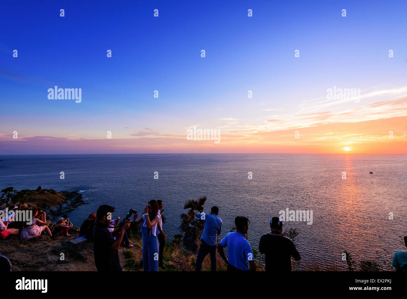PHUKET, THAILAND - 28. April 2015: Große Gruppe von Touristen fotografieren und warten auf den Sonnenuntergang über dem Meer am Laem Phrom Stockfoto