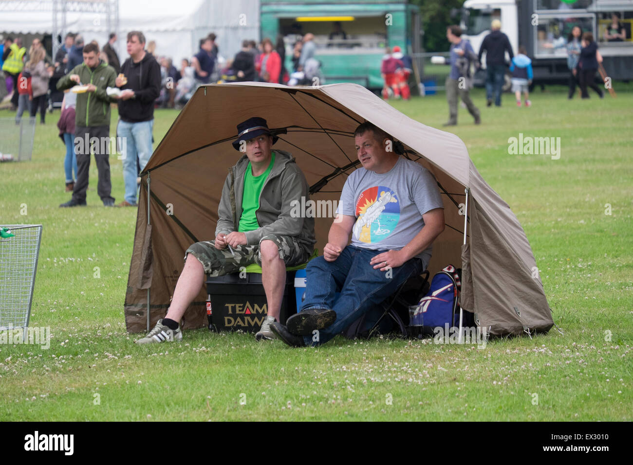 Männer mit Zelt Musik Festival feuchten Nass beobachten Stockfoto