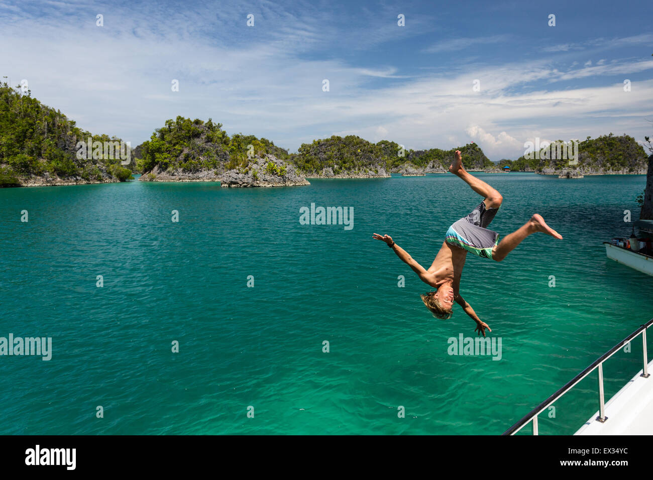 Ein junger Mann hat einen Flip von einem Boot in Raja Ampat Fam Inseln. Stockfoto