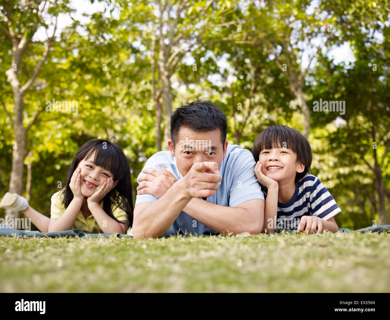 Vater und Kinder spielen im freien Stockfoto
