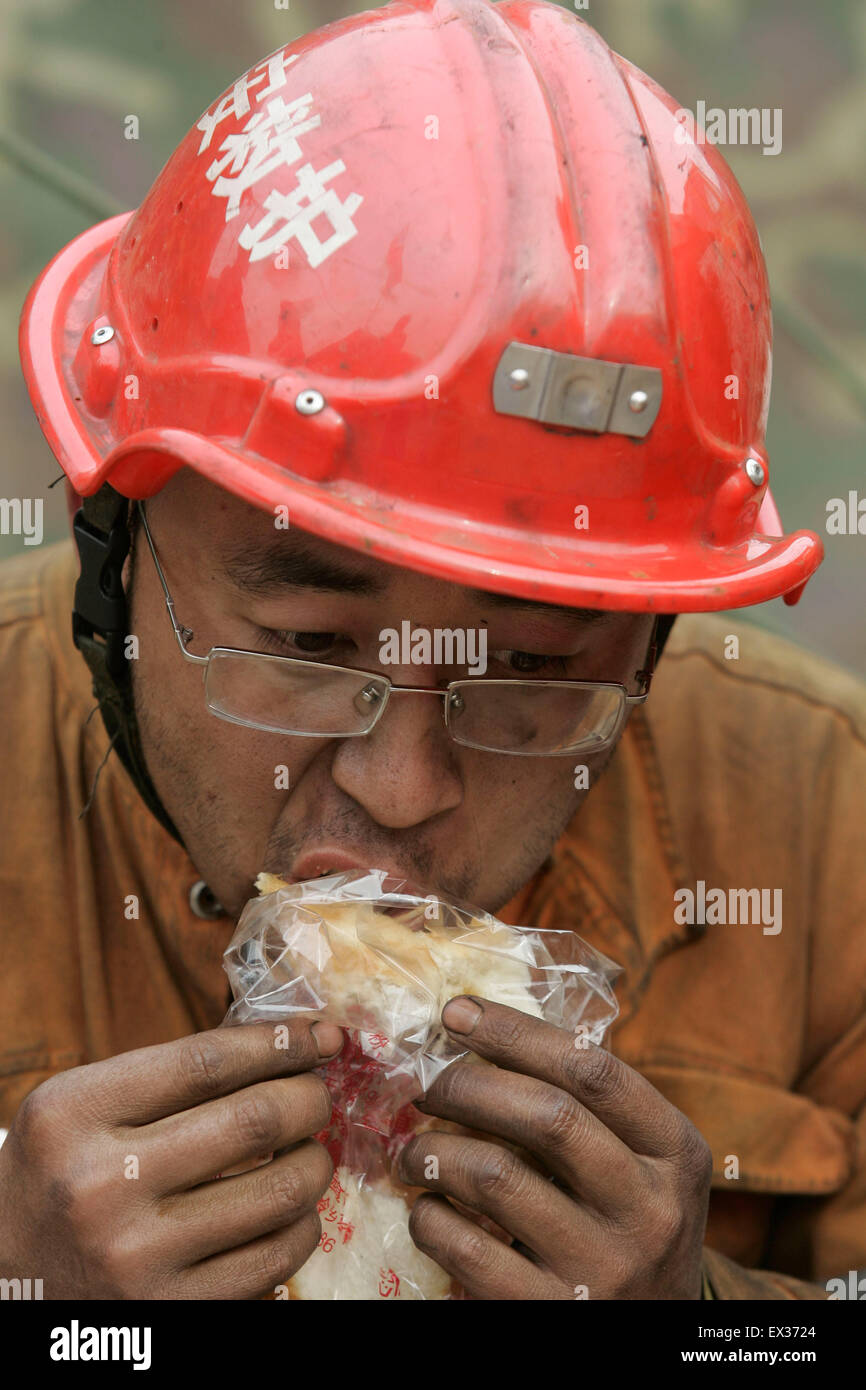 Ein Retter isst, nach eine Mission an den überfluteten Wangjialing Coal Mine, befindet sich in Xiangning Landkreis und Stadt Hejin, Sha Stockfoto
