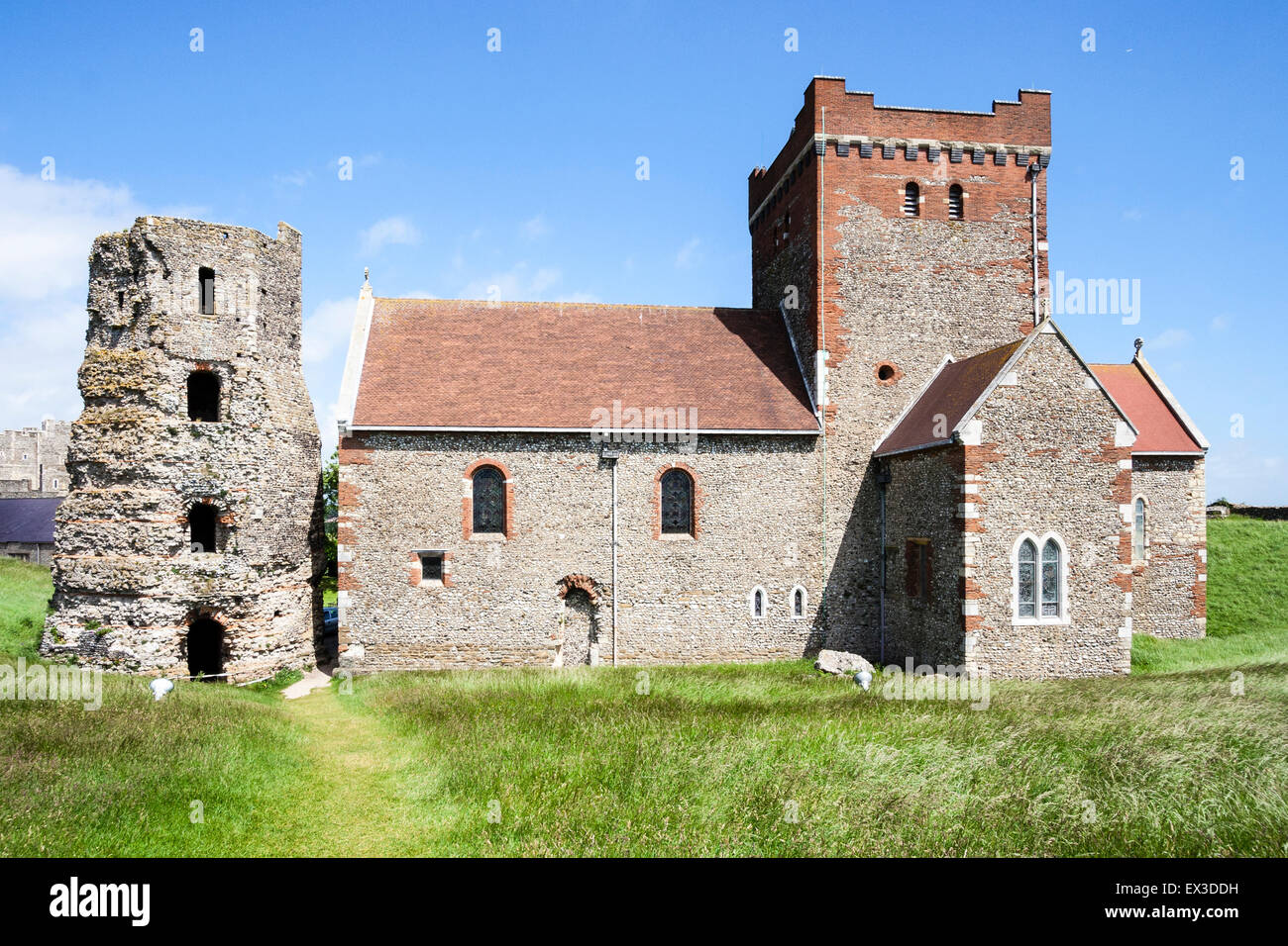 Die Ruinen des 2. Jh. römische Leuchtturm, Pharos, mit der steinernen Kirche St. Maria in Castro Kirche im Dover Castle unter blauem Himmel. Stockfoto