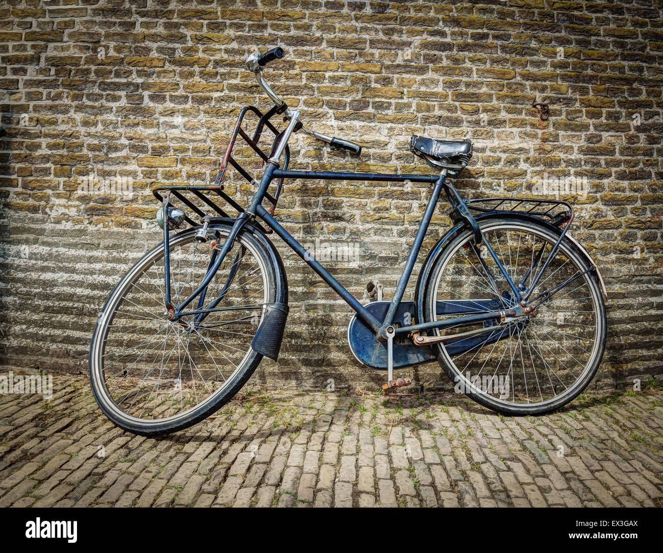 Altmodisches Fahrrad gegen eine Mauer gelehnt Stockfoto