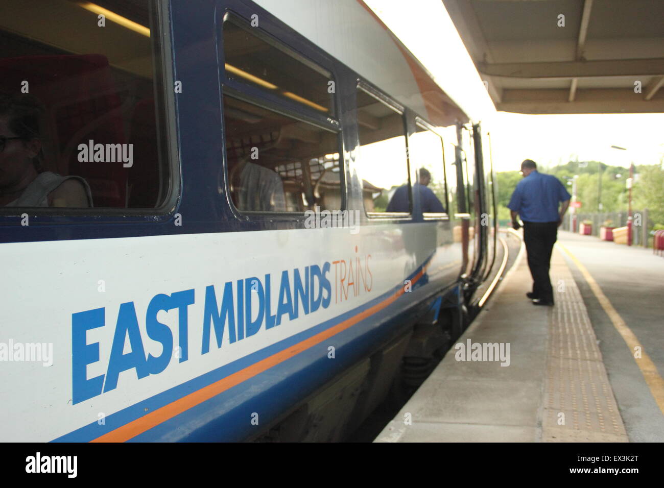 Ein Lokführer nähert sich die Kabine eines East Midlands-Zuges am Bahnhof Matlock, Derbyshire England UK Stockfoto