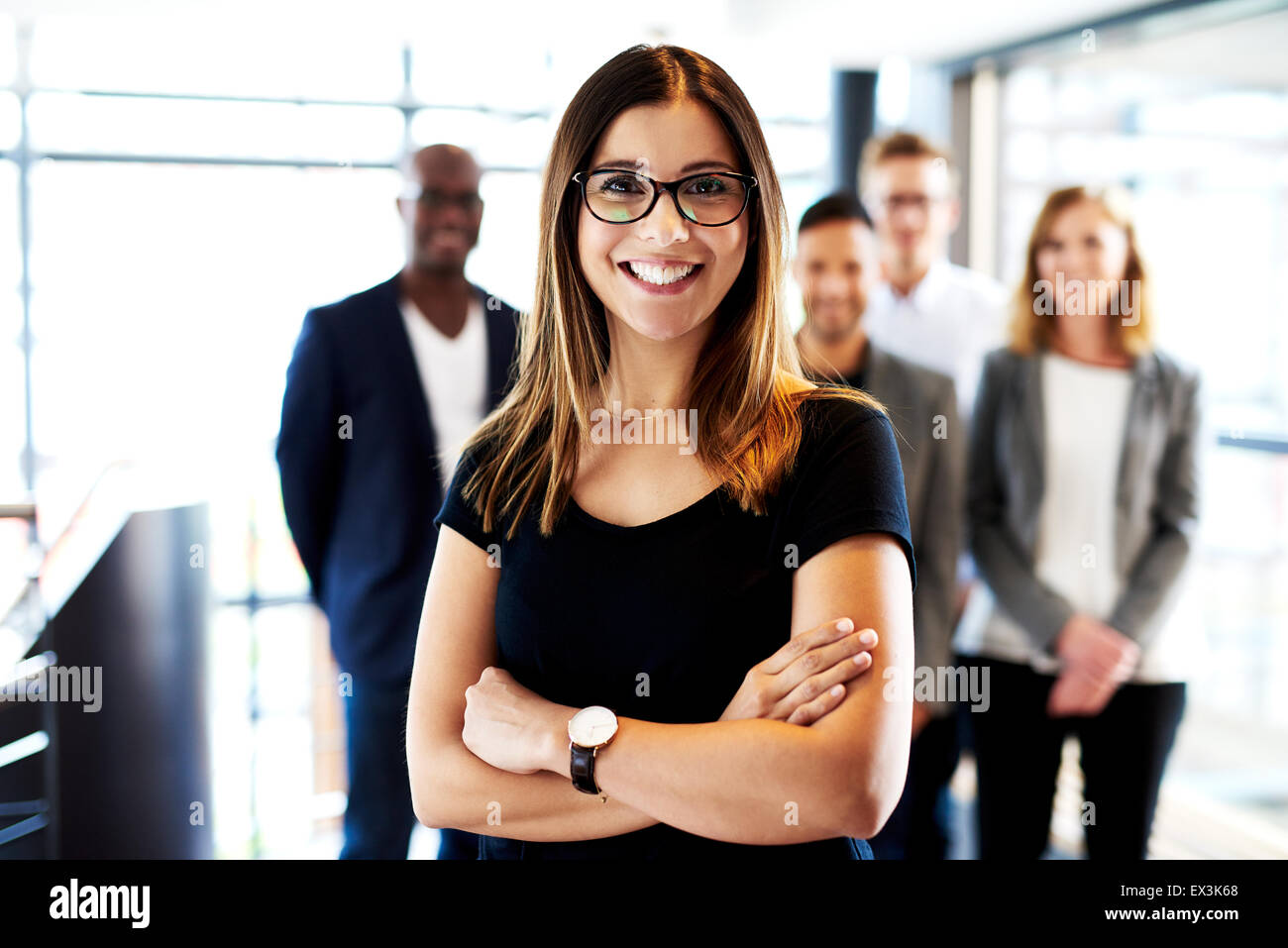 Junge weiße Frau executive stand vor der Kollegen mit verschränkten Armen und lächelnd Stockfoto