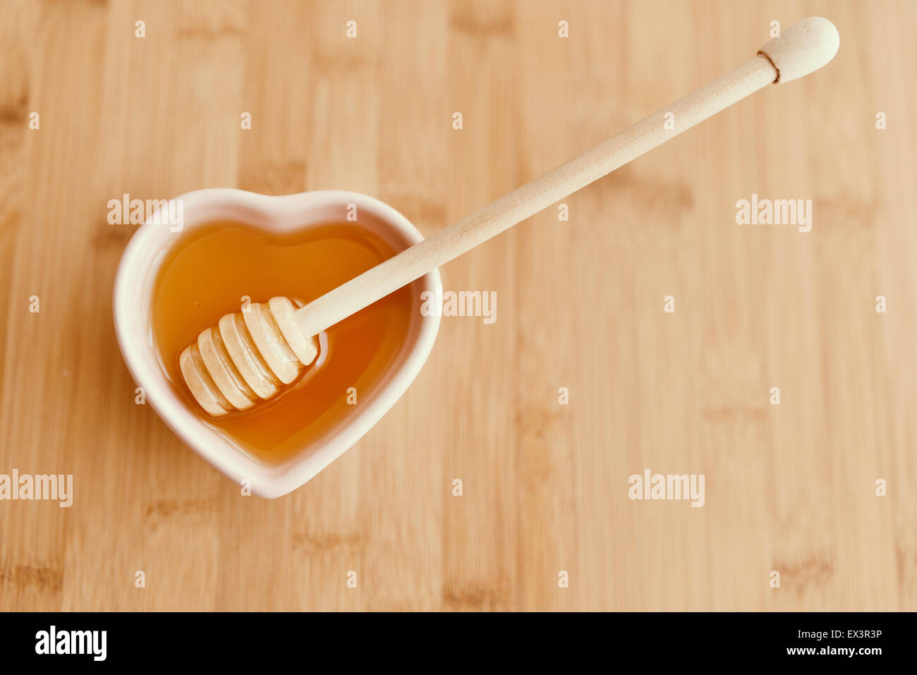 Schale mit Honig auf Holztisch. Stockfoto