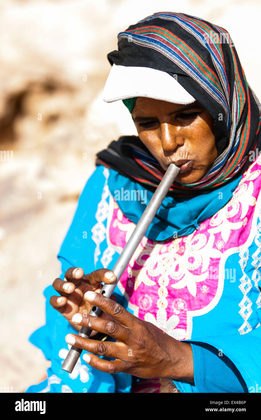 Petra, Jordanien, 8. Juni. Ein Beduinen-Frau spielt eine kleine Metallflöte. Stockfoto