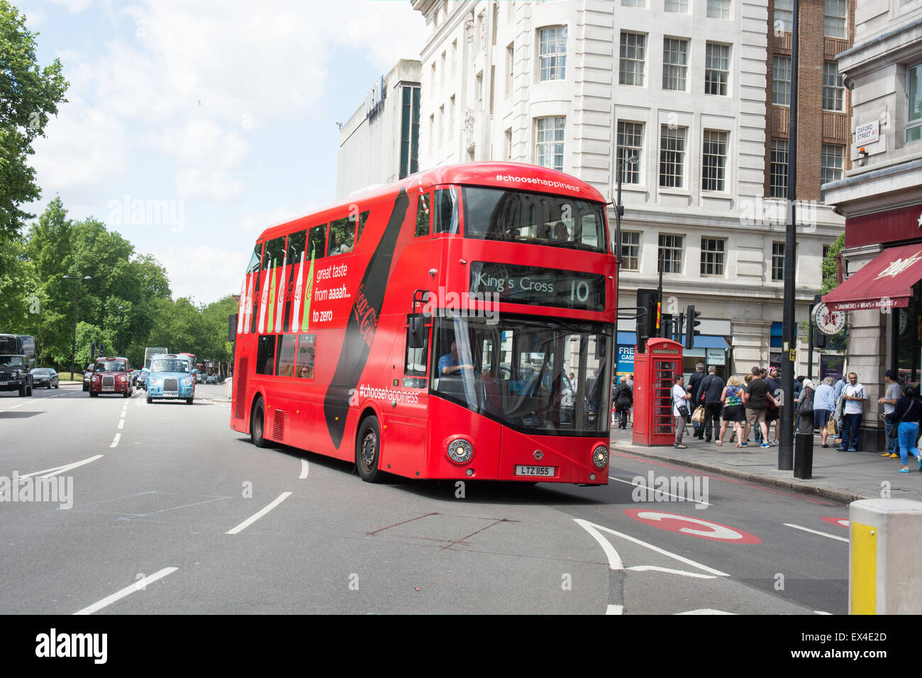 Ein neuer Bus tritt für London (neue Routemaster) fällt im ganzen Werbung für Coca Cola Oxford Street von Marble Arch Stockfoto