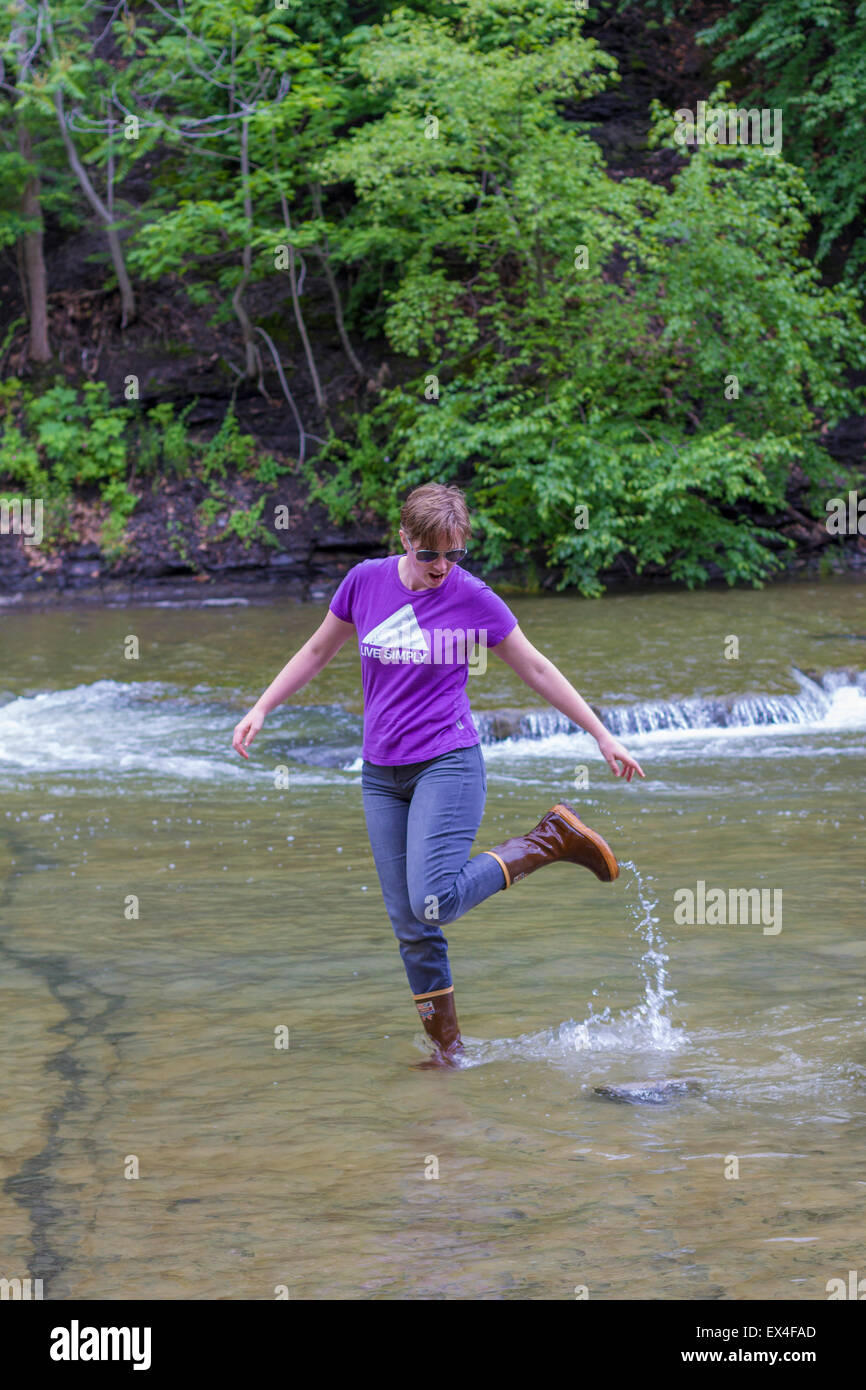 Eine Frau spritzt in einem Fluss in der Finger Lakes Region von New York Stockfoto