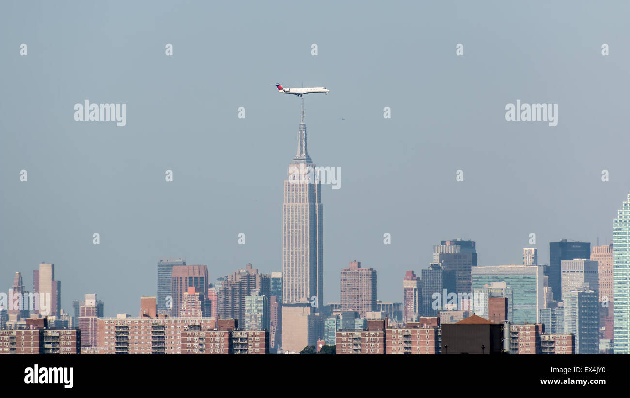 Flugzeuge landen am Flughafen LaGuardia fliegen tief über die Wolkenkratzer von New York Stockfoto