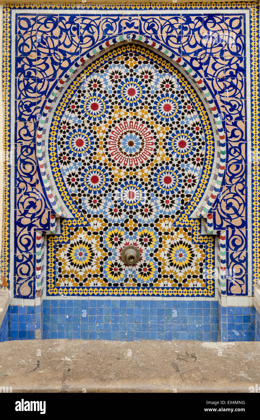 Traditioneller Kachelofen Brunnen mit Messing Wasser Auslauf an der Außenwand einer Moschee in Rabat, Marokko Stockfoto