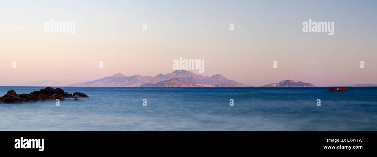 Romantischer Sonnenuntergang mit einem kleinen roten Boot, Griechenland, Insel Kos. Stockfoto