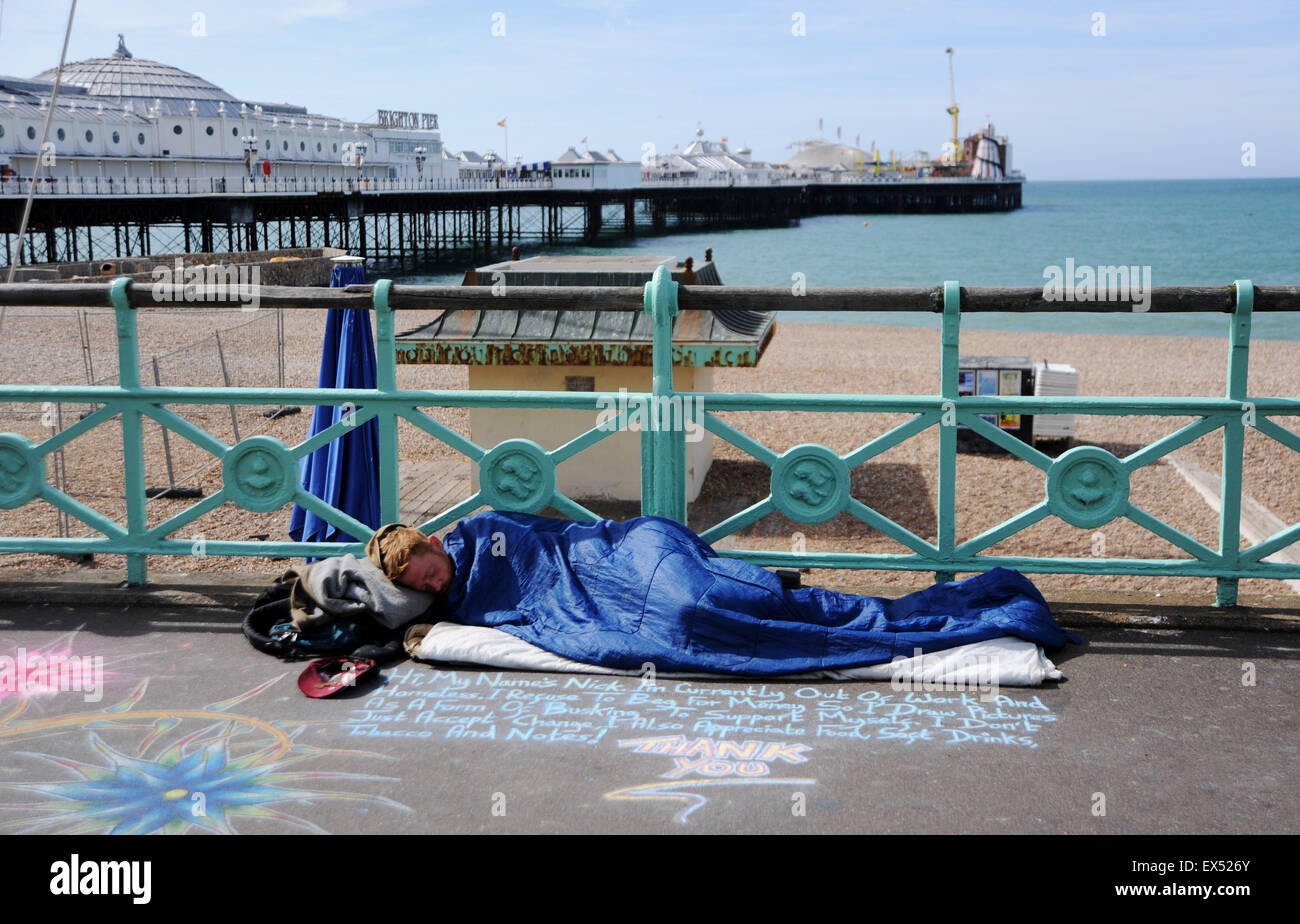 Junger Mann der Straße Bürgersteig Künstler auf Brighton Seafront in einem Schlafsack im Laufe des Tages Stockfoto